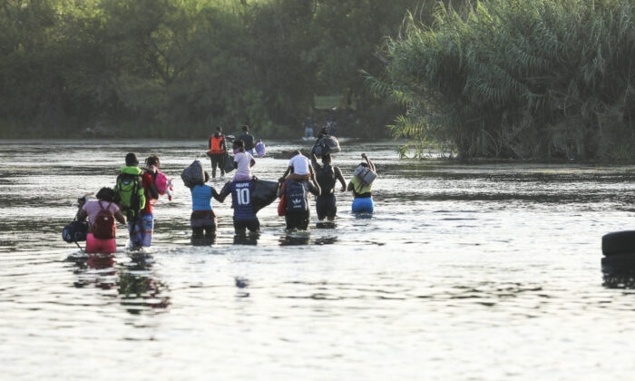 A group of illegal immigrants crosses the Rio Grande from Acuna, Mexico, to Del Rio, Texas, on July 25, 2021. (Charlotte Cuthbertson/The Epoch Times)