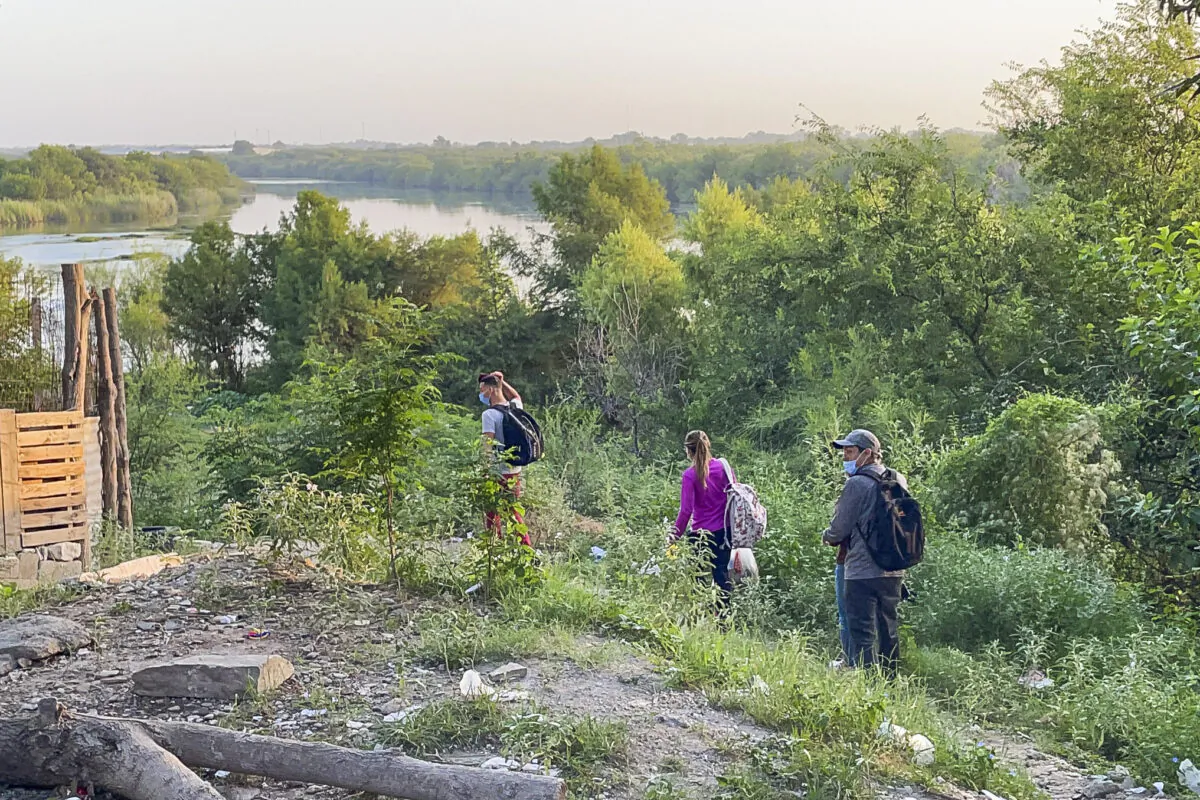A group of Cubans walks toward the Rio Grande to cross illegally into Del Rio, Texas, from Acuna, Mexico, on July 25, 2021. (Charlotte Cuthbertson/The Epoch Times)