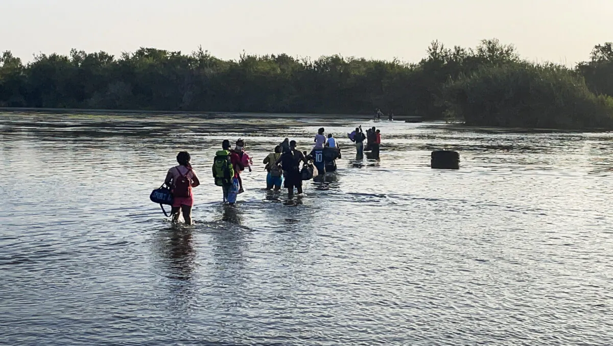 A group of illegal immigrants crosses the Rio Grande from Acuña, Mexico, to Del Rio, Texas, on July 25, 2021. (Charlotte Cuthbertson/The Epoch Times)