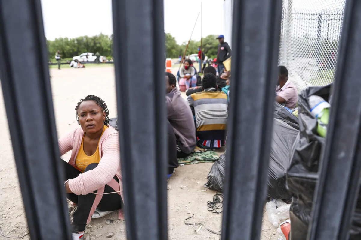 A group of more than 350 illegal immigrants wait for Border Patrol after crossing the Rio Grande from Mexico into Del Rio, Texas, on July 25, 2021. (Charlotte Cuthbertson/The Epoch Times)