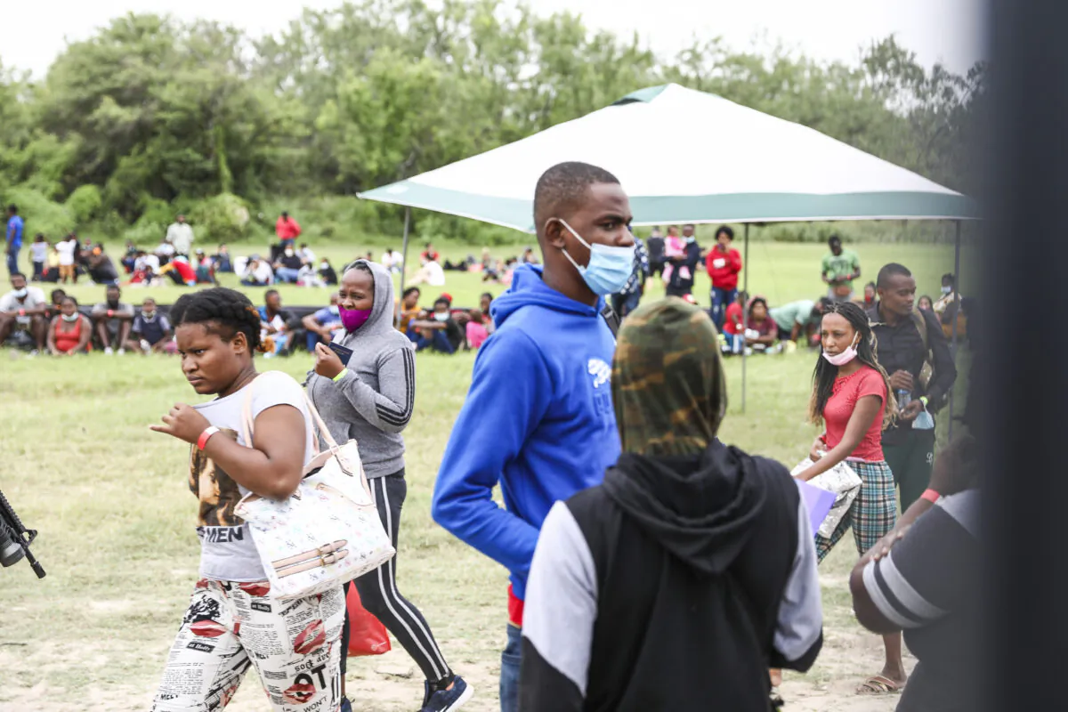 A group of more than 350 illegal immigrants waits for Border Patrol after crossing the Rio Grande from Mexico into Del Rio, Texas, on July 25, 2021. (Charlotte Cuthbertson/The Epoch Times)