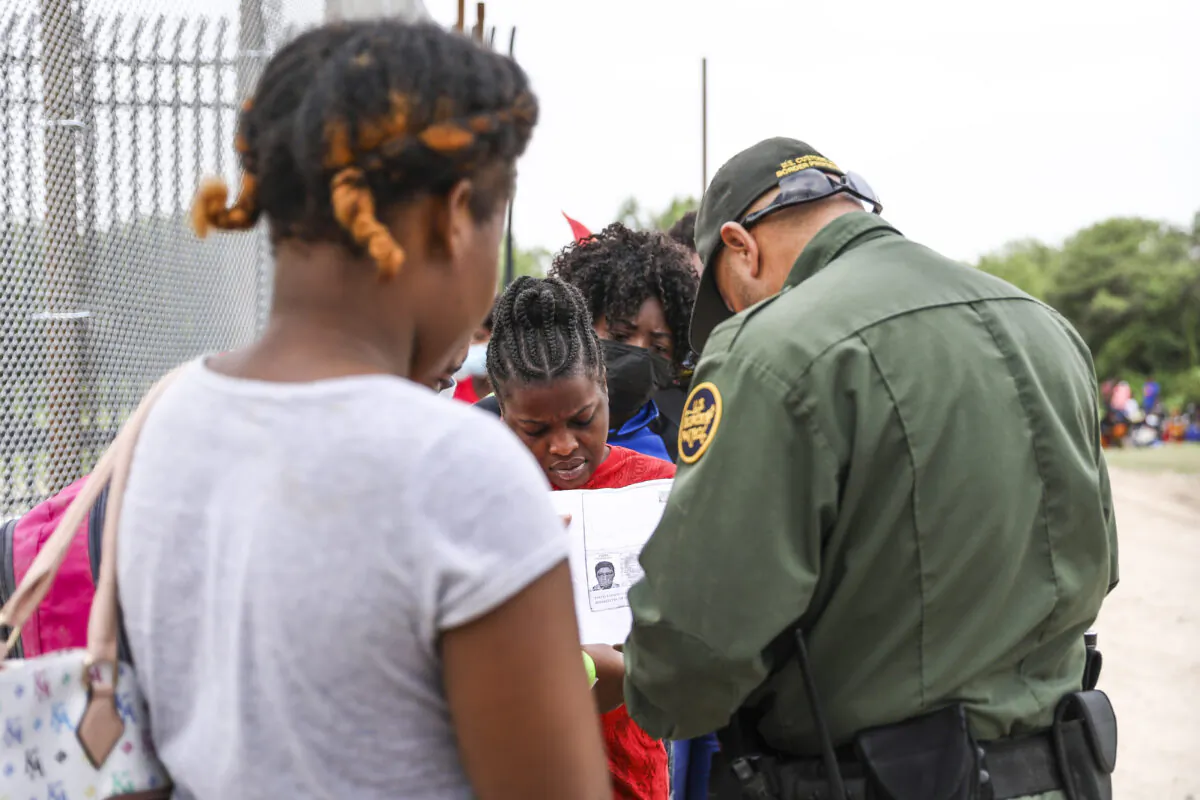 A Border Patrol agent starts organizing a group of more than 350 illegal immigrants after they crossed the Rio Grande from Mexico into Del Rio, Texas, on July 25, 2021. (Charlotte Cuthbertson/The Epoch Times)