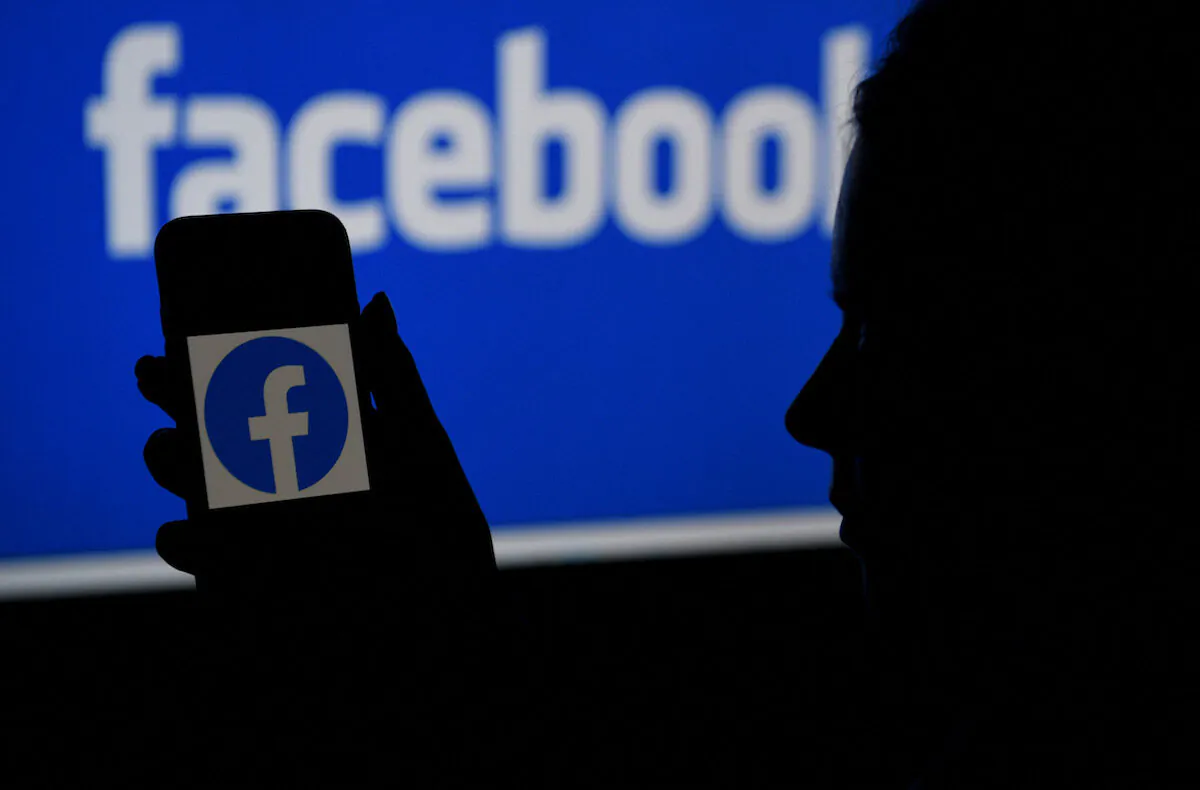 A smart phone screen displays the logo of Facebook with a Facebook website background in Arlington, Va., on April 7, 2021. (Olivier Douliery/AFP via Getty Images)