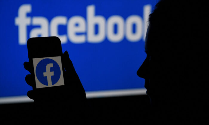 A smart phone screen displays the logo of Facebook with a Facebook website background in Arlington, Va., on April 7, 2021. (Olivier Douliery/AFP via Getty Images)