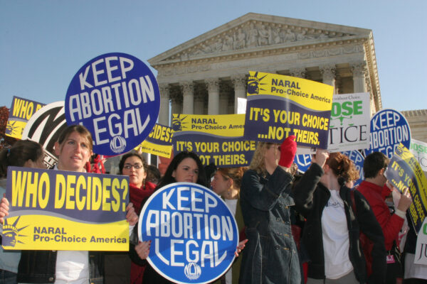 Pro-choice demonstrators wave signs in front of the U.S. Supreme Court as it prepares to take up an abortion case, in Washington on Nov. 30, 2005. (Karen Bleier/AFP via Getty Images)