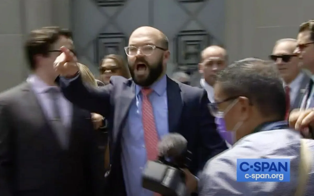 A screenshot from a C-Span video showing the moment Nick Dyer, Rep. Greene’s communications director, announces the press conference held by five GOP lawmakers was over, as protesters swarmed the event, outside the Department of Justice in Washington on July 27, 2021. (Screenshot C-Span/The Epoch Times)
