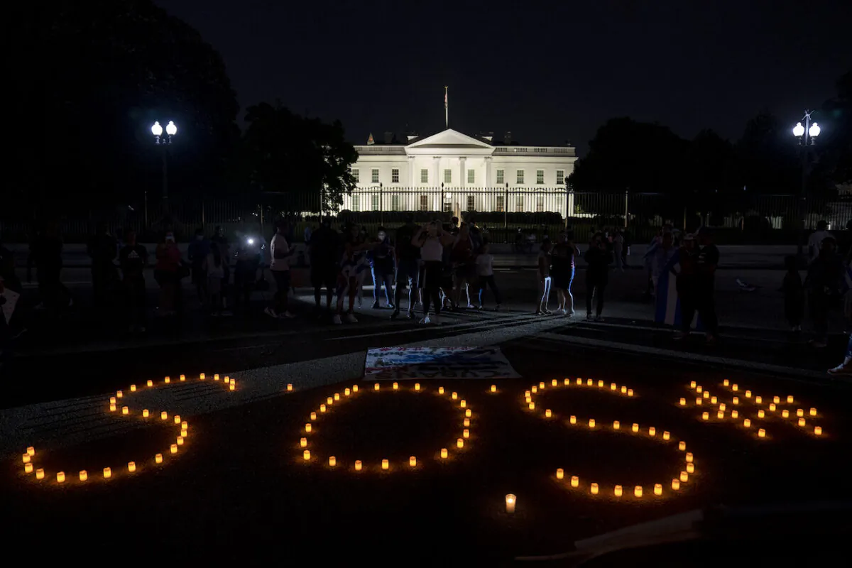 Demonstrators use candles to spell out SOS in solidarity with protests in Cuba outside the White House in Washington, DC, on July 18, 2021. (Stefani Reynolds/Getty Images)