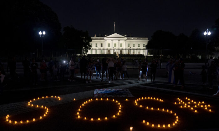 Demonstrators use candles to spell out SOS in solidarity with protests in Cuba outside the White House in Washington, DC, on July 18, 2021. (Stefani Reynolds/Getty Images)