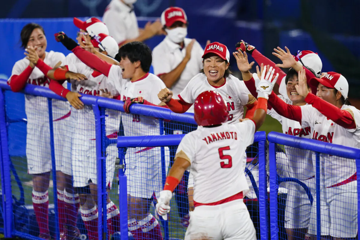Japan’s Yu Yamamoto (5) celebrate with teammates after scoring on a single in the fifth inning of a softball game against the United States at the 2020 Summer Olympics, in Yokohama, Japan, on July 27, 2021. (Matt Slocum/AP Photo)