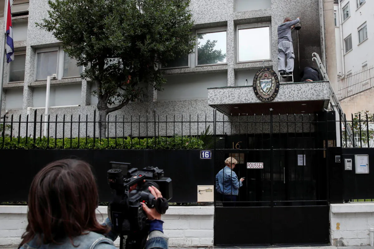 Workers fix the damage at the Cuban embassy following an overnight petrol bomb attack on its building, in Paris, France, on July 27, 2021. (Benoit Tessier/Reuters)