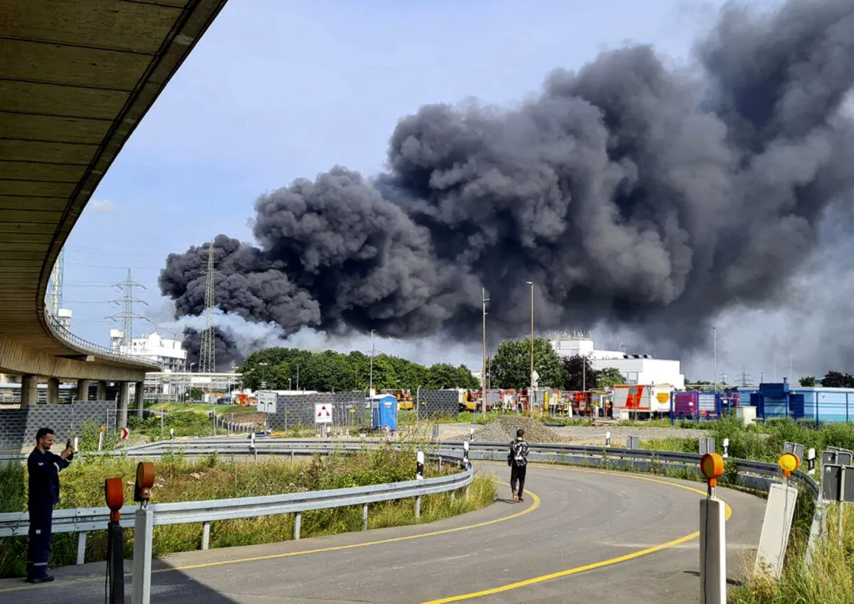 A dark cloud of smoke rises above the chemical park in Leverkusen, Germany, on July 27, 2021. (Mirko Wolf/dpa via AP)