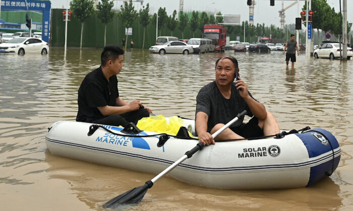 People uses a rubber dinghy to cross a flooded street following flooding that claimed the lives of at least 33 people earlier in the week, in the city of Zhengzhou in China's Henan province on July 23, 2021. (Noel Celis/AFP via Getty Images)