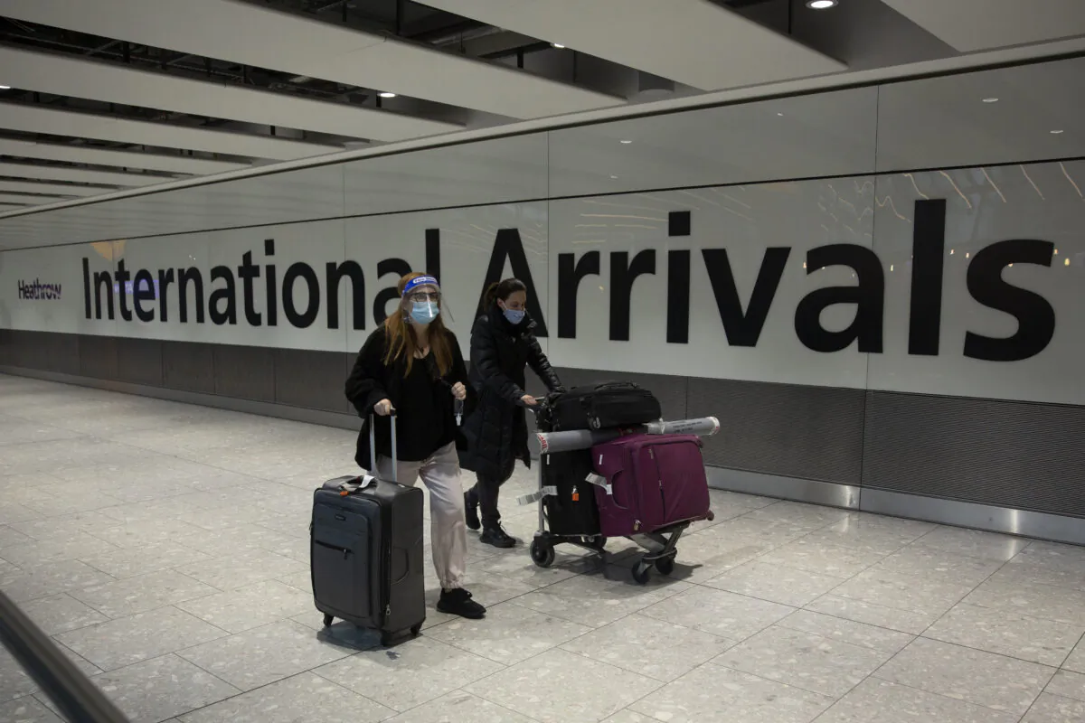 Passengers walk in the arrivals area at Heathrow Airport, in London, on Jan. 18, 2021. (AP Photo/Matt Dunham)