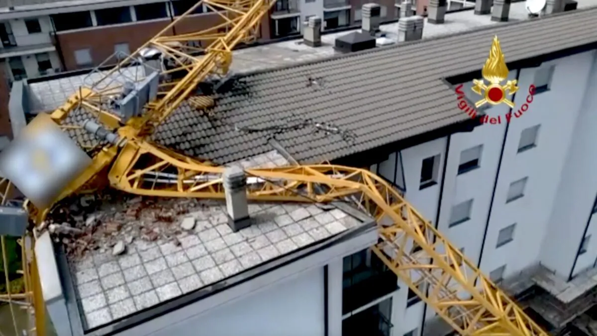 A giant crane collapsed on top of a six-story building in Milan, Italy, on July 27, 2021. (Italian Firefighters Handout via AP/Screenshot via The Epoch Times)