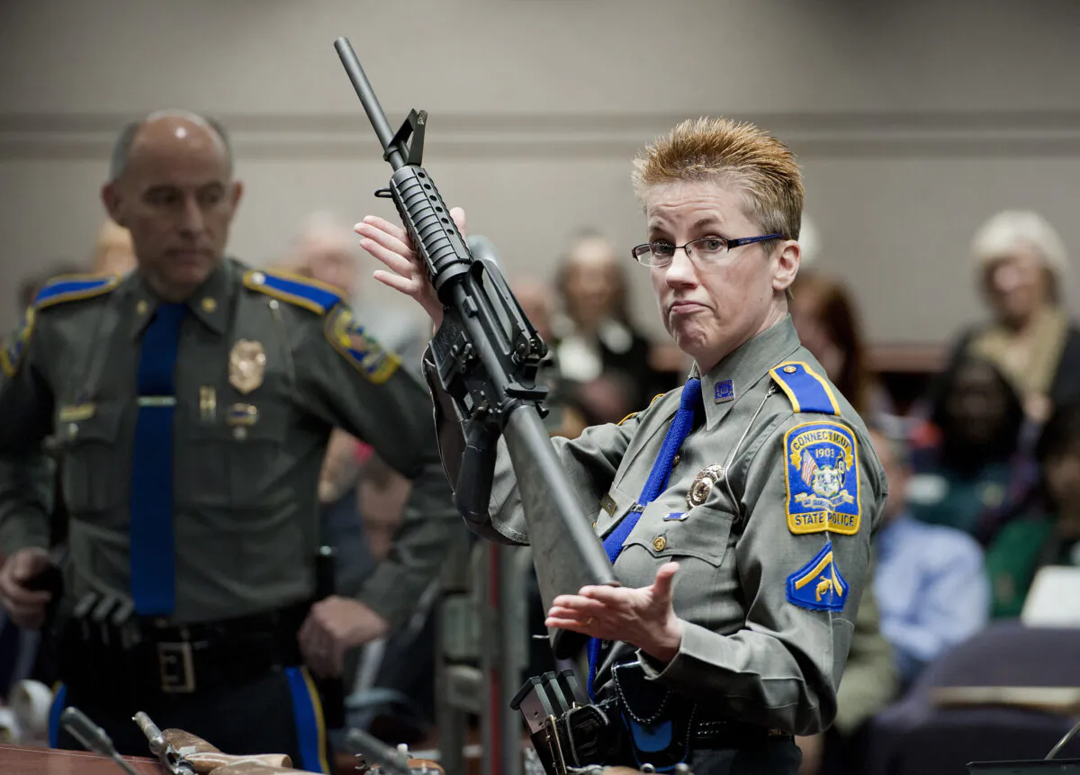 Firearms training unit Detective Barbara J. Mattson, of the Connecticut State Police, holds up a Bushmaster AR-15 rifle, the same make and model of gun used by Adam Lanza in the Sandy Hook School shooting, for a demonstration during a hearing of a legislative subcommittee reviewing gun laws, at the Legislative Office Building in Hartford, Conn., on Jan. 28, 2013. (Jessica Hill/AP Photo)