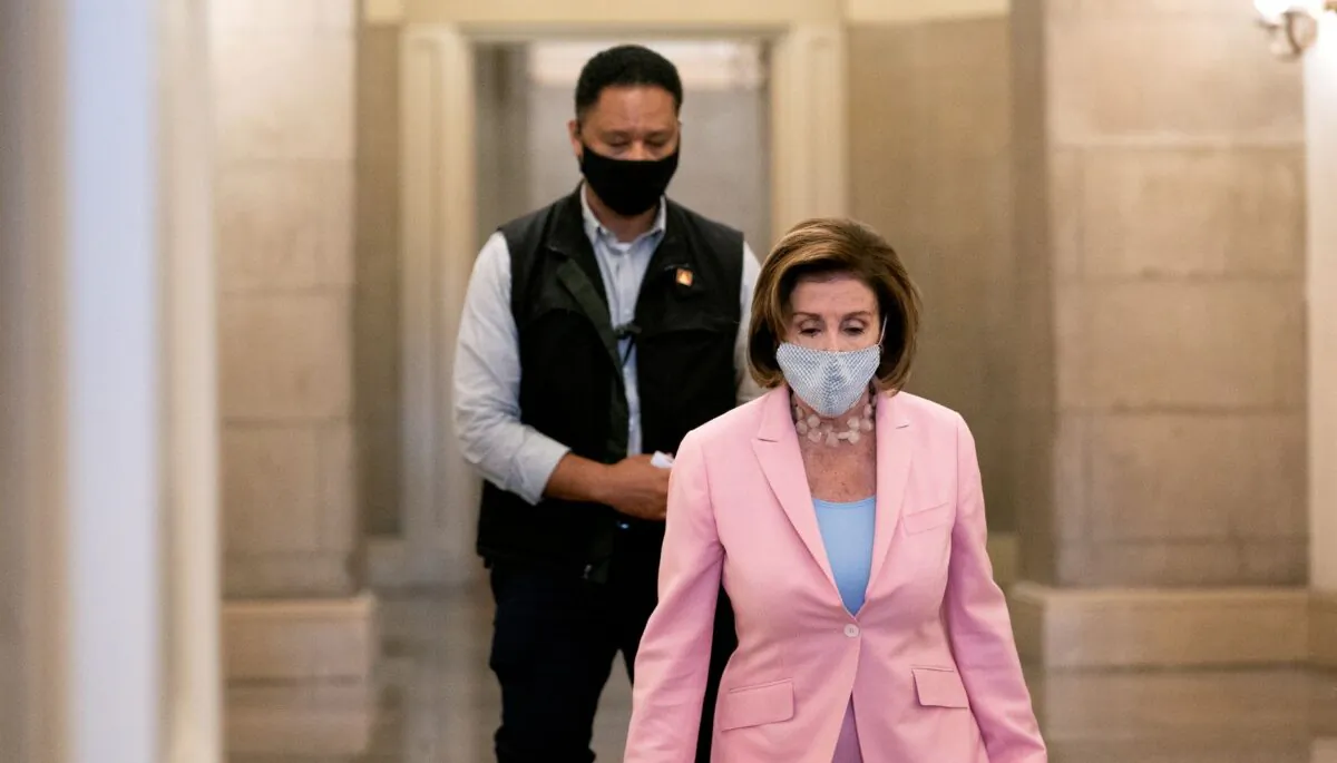 House Speaker Nancy Pelosi (D-Calif.) (C) wears a protective mask while departing the U.S. Capitol in Washington on July 25, 2021. (Stefani Reynolds/Getty Images)