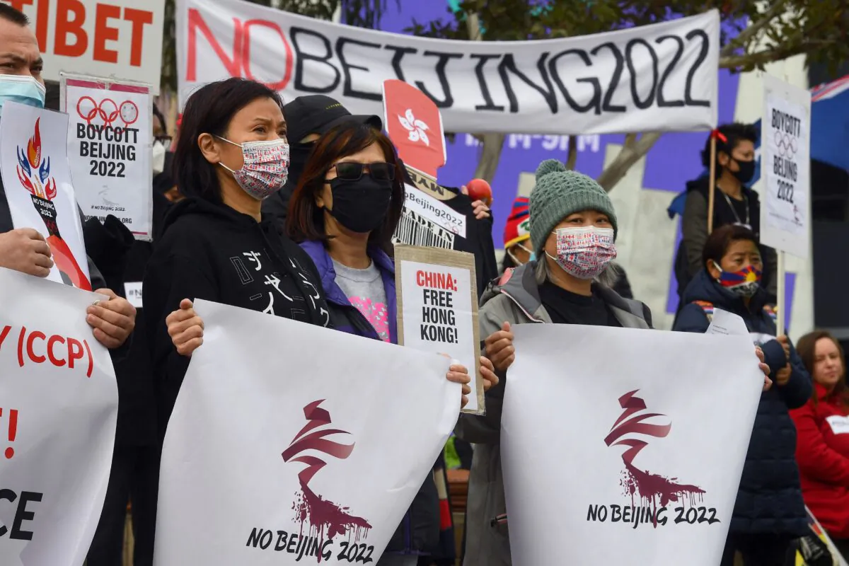 Activists including members of the local Hong Kong, Tibetan and Uyghur communities hold up banners and placards in Melbourne on June 23, 2021, calling on the Australian government to boycott the 2022 Beijing Winter Olympics over China's human rights record. (Photo by William WEST / AFP) (Photo by WILLIAM WEST/AFP via Getty Images)