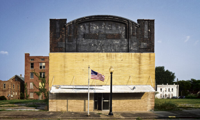 A U.S. flag flies before a closed theater on Eighth Street in Cairo, Ill., on July 20, 2021. (Jackson Elliott/The Epoch Times)