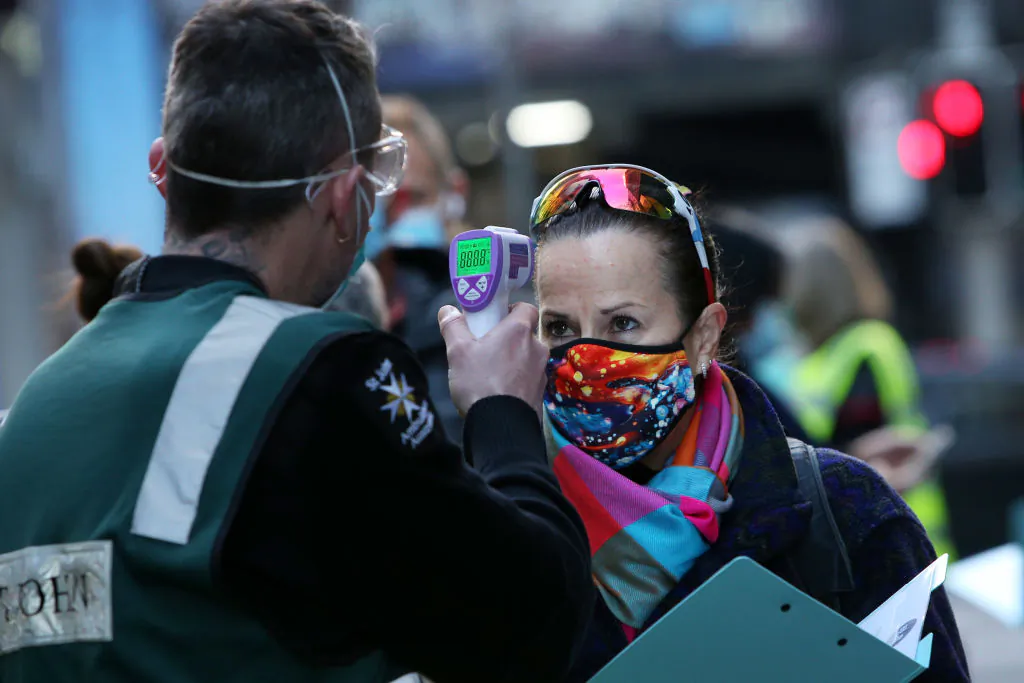 A St John Ambulance staff member takes the temperature of a client arriving at a COVID-19 Vaccination Centre in the CBD in Sydney, Australia on July 19, 2021. (Lisa Maree Williams/Getty Images)