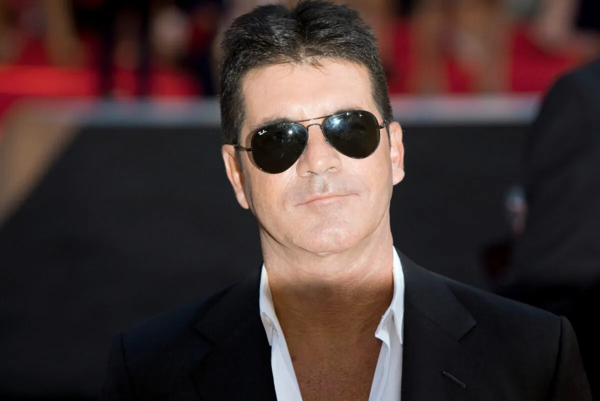 Television mogul Simon Cowell poses for photographers as he arrives for the film "One Direction: This is Us," in London, England, on Aug. 20, 2013. (Neil Hall/Reuters)