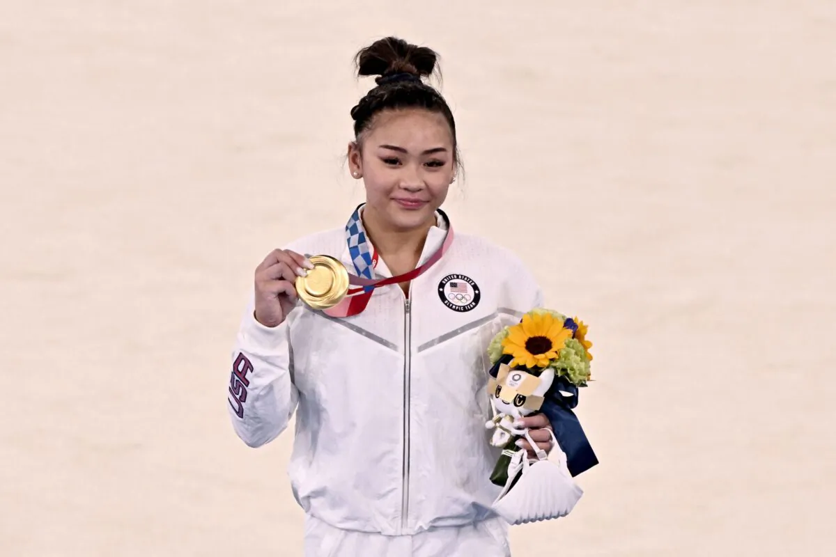 Sunisa Lee of the United States (gold) celebrates on the podium during the medal ceremony of the artistic gymnastics women's all-around final during the Tokyo 2020 Olympic Games at the Ariake Gymnastics Centre in Tokyo, Japan, on July 29, 2021. (Lionel Bonaventure/AFP via Getty Images)