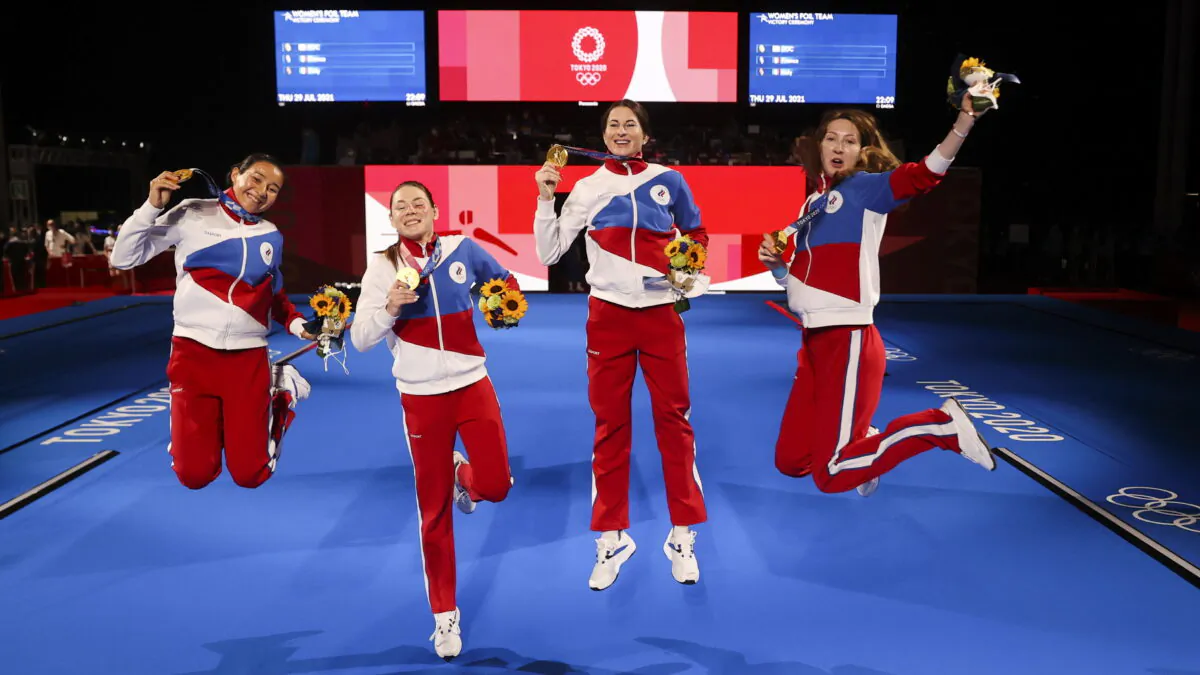 Gold medalists Inna Deriglazova, Adelina Zagidullina, Larisa Korobeynikova, and Marta Martyanova of the ROC celebrate their victory during the medal ceremony for the women's foil team at the Tokyo 2020 Olympic Games at the Makuhari Messe Hall in Chiba City, Chiba Prefecture, Japan, on July 29, 2021. (Carl Recine/Reuters)