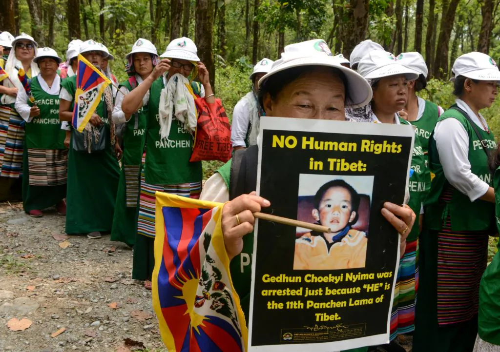 Members of the Tibetan Women's Association hold posters as they take part in a silent march commemorating the disappearance of the child Panchen Lama, on April 29, 2019.(Dipendu Dutta/AFP via Getty Images)