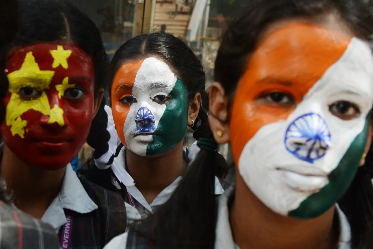 Indian school students pose with their faces painted with India's and China's (L) national flags in Chennai on October 10, 2019, ahead of a summit between Indian PM, Narendra Modi and China's leader Xi Jinping in the Indian city of Chennai. (Arun Sankar/AFP via Getty Images)