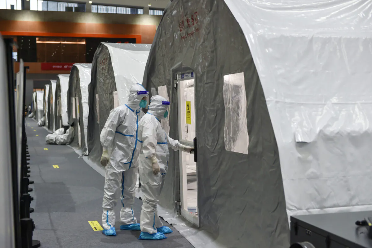 Staff members checking a unit at a temporary "Fire Eye" laboratory used for COVID-19 testing, at an exhibition center in Nanjing, Jiangsu Province, China on July 28, 2021. (STR/AFP via Getty Images)