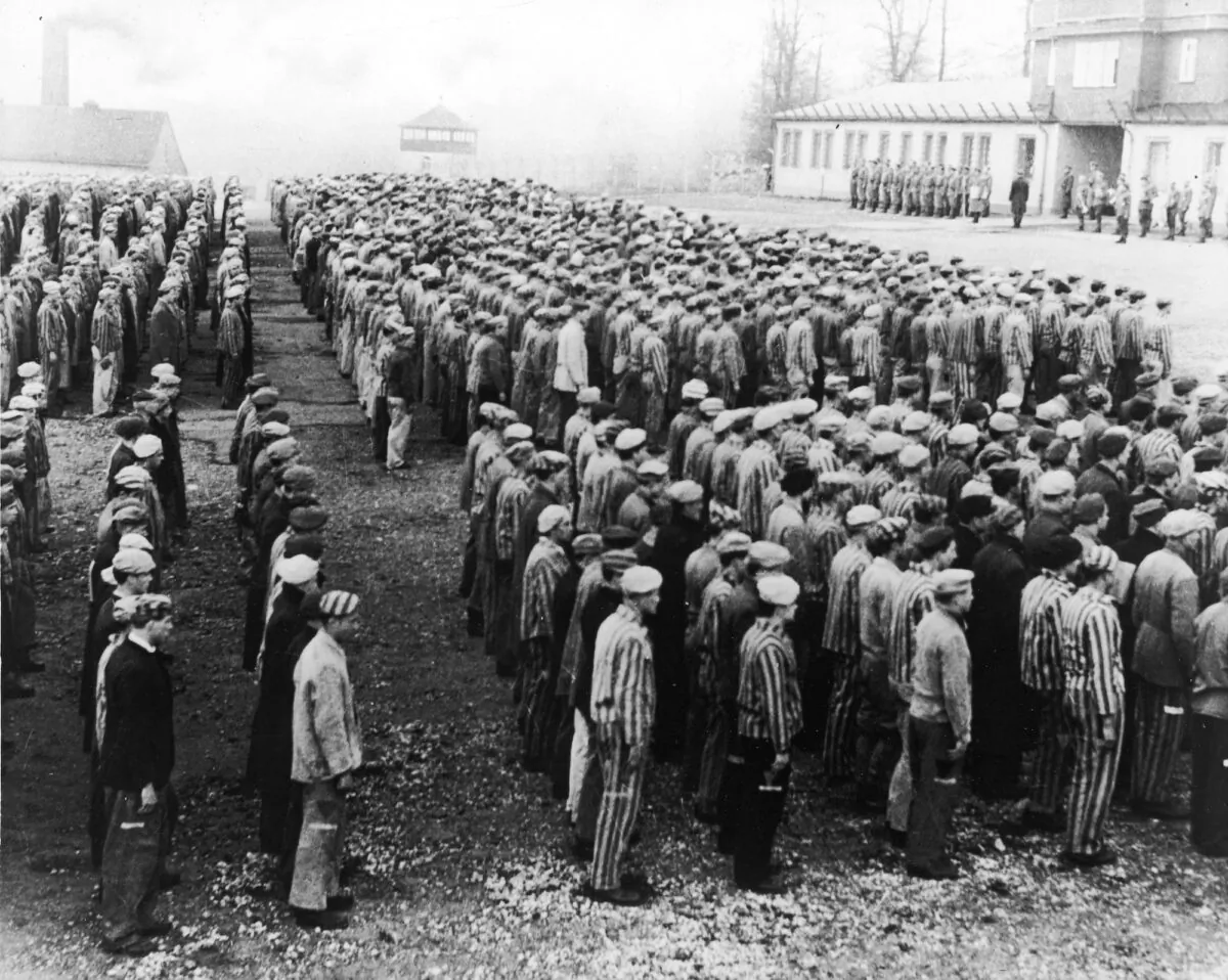 Polish prisoners in striped uniforms stand in rows before Nazi officers at the Buchenwald Concentration Camp, Weimar, Germany, World War II, circa 1943. (Frederic Lewis/Getty Images)

