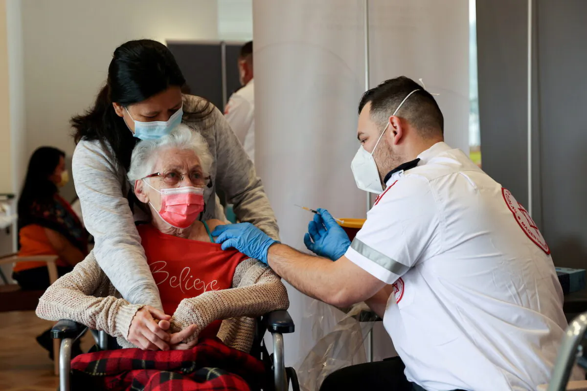 An elderly woman receives a booster shot of her vaccination against the coronavirus at an assisted living facility, in Netanya, Israel, on Jan. 19, 2021. (Ronen Zvulun/Reuters)