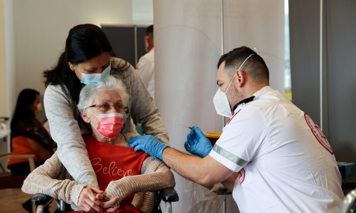 Une femme âgée reçoit un rappel de sa vaccination contre le virus du PCC dans une résidence-services, à Netanya, en Israël, le 19 janvier 2021. (Ronen Zvulun/Reuters)