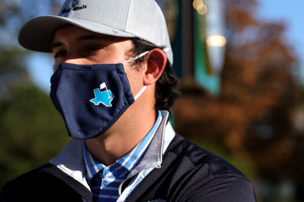 A staff member wears a Texas themed mask