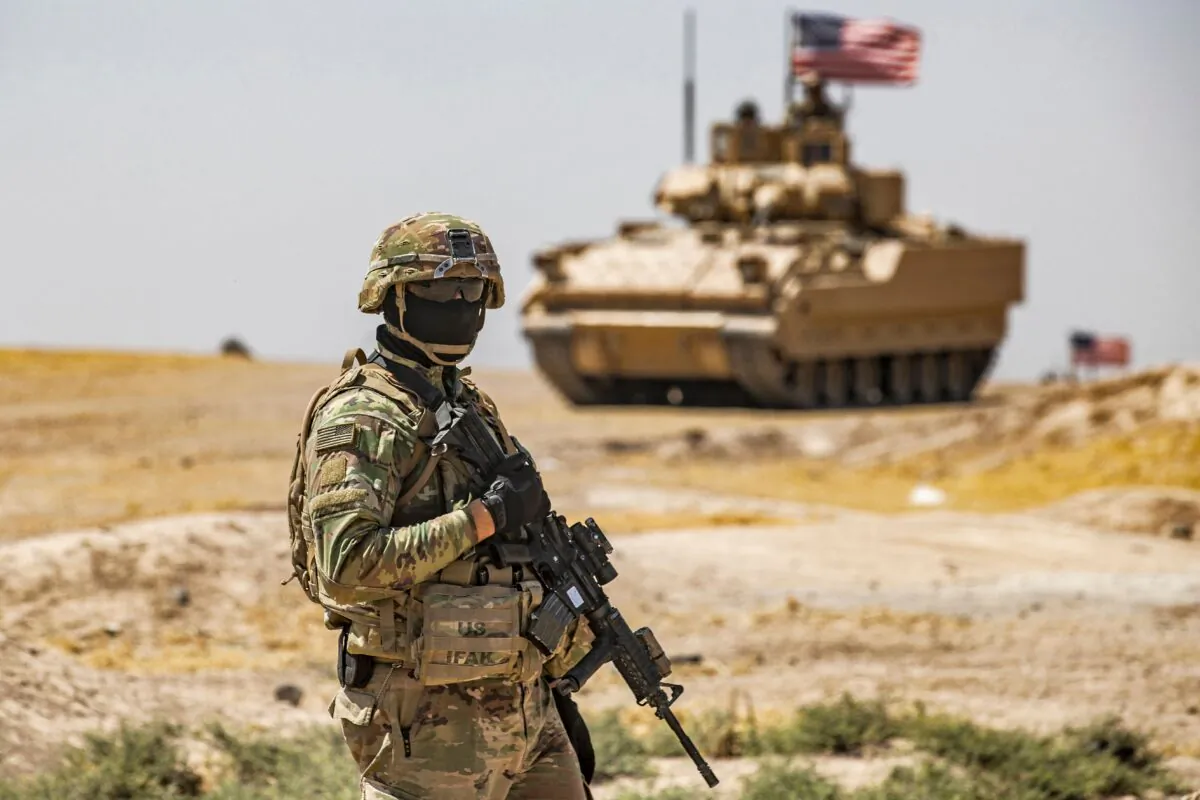 A U.S. soldier stands near a Bradley Fighting Vehicle (BFV) during a patrol near the Rumaylan (Rmeilan) oil wells in Syria's northeastern Hasakeh province, on June 22, 2021. (Delil Soulieman/AFP via Getty Images)