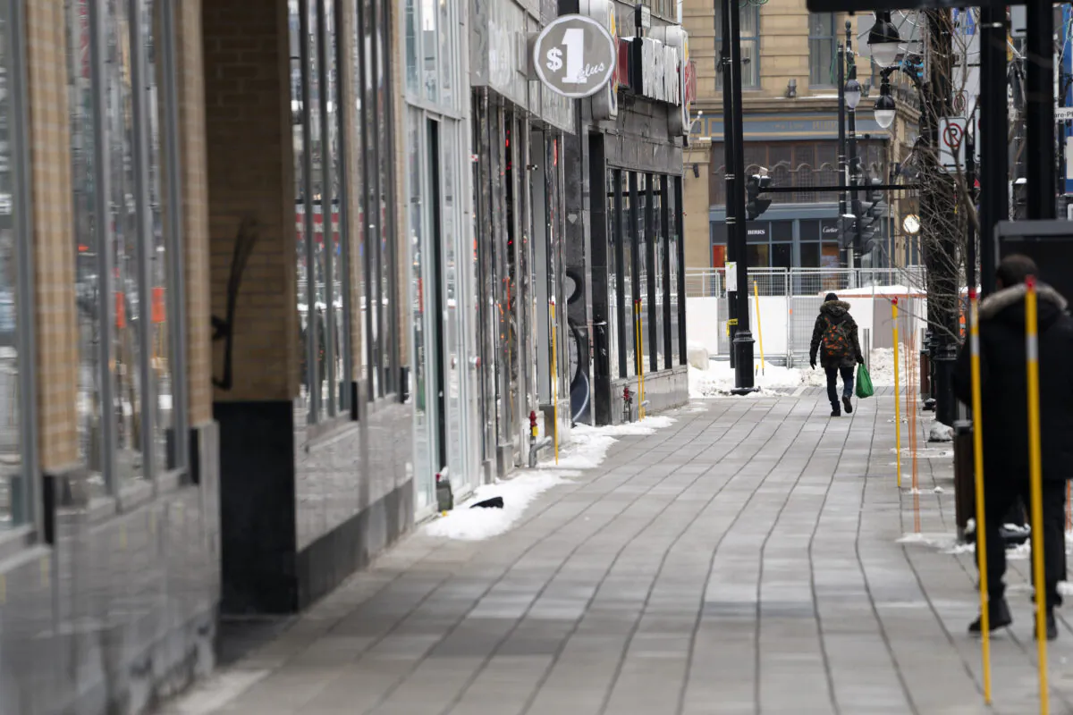 A man walks down a quiet Saint-Catherine Street under Quebec's new COVID-19 lockdown in Montreal on Jan. 11, 2021. (The Canadian Press/Paul Chiasson)
