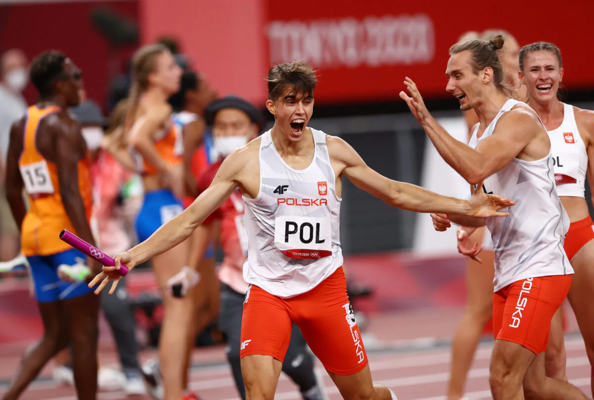 Kajetan Duszynski of Poland celebrates with Karol Zalewski of Poland after winning the 4x400m mixed relay final during the Tokyo 2020 Olympic Games at the Olympic Stadium in Tokyo, Japan, on July 31, 2021. (Kai Pfaffenbach/Reuters)