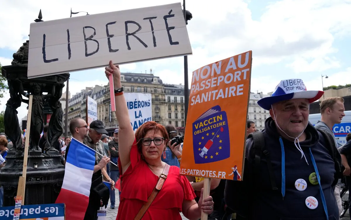 A protestor holds a sign which reads in French "freedom" and "no to the Covid passport" as she attends a demonstration in Paris on July 31, 2021. (Michel Euler /AP Photo)