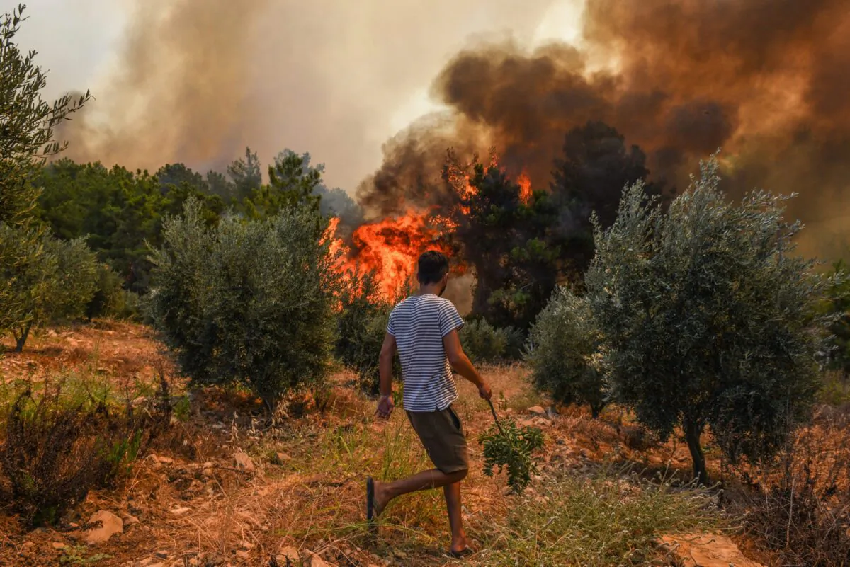 A man walks toward wildfires in Kacarlar village near the Mediterranean coastal town of Manavgat, Antalya, Turkey, on July 31, 2021. (AP Photo)
