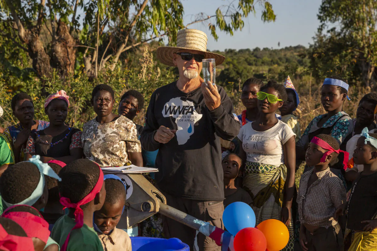 Water Wells or Africa founder Kurt Dahlin tests the water with Juma 2B villagers on July 2, 2021. (John Fredricks/The Epoch Times)