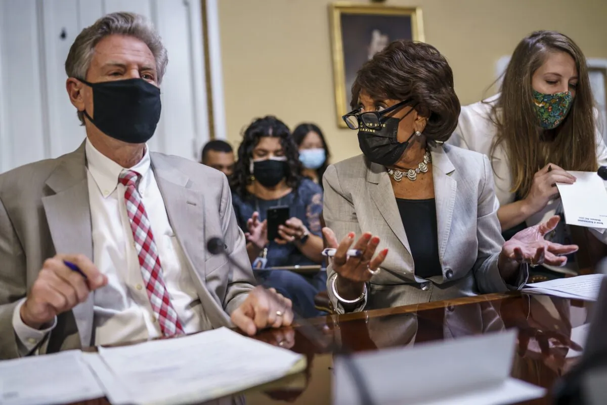 House Financial Services Committee Chairwoman Maxine Waters (D-Calif.) (C) gestures while speaking to House Energy and Commerce Chairman Frank Pallone (D-N.J.) as they prepare an emergency extension of the eviction moratorium, at the U.S. Capitol in Washington on July 30, 2021. (J. Scott Applewhite/AP Photo)