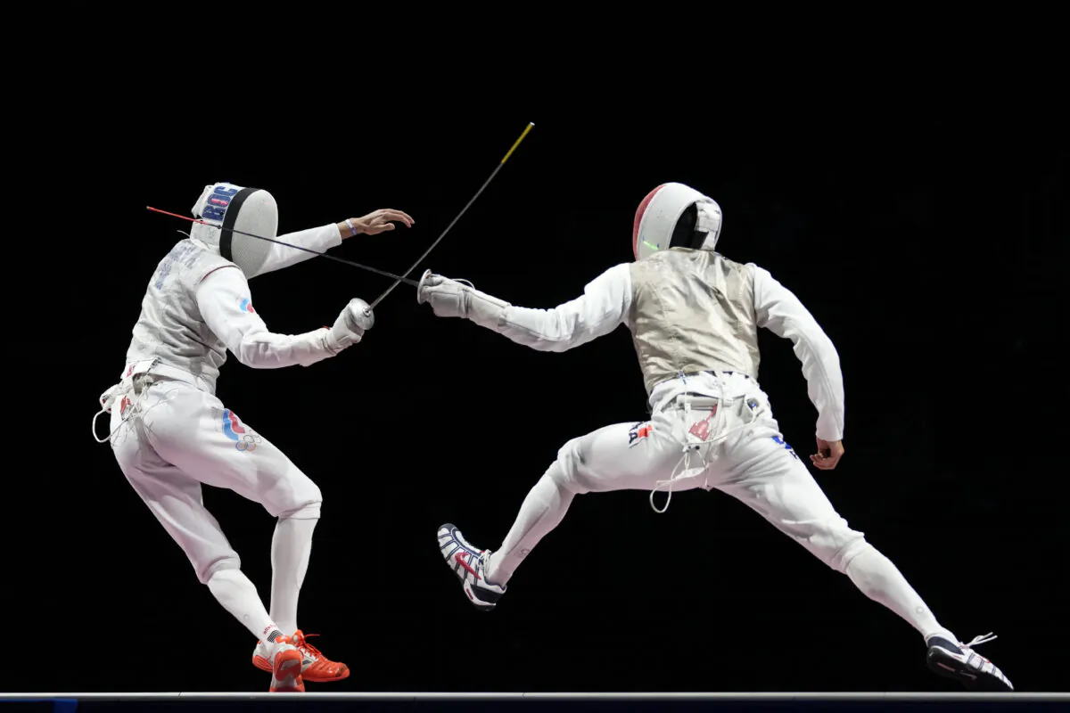 Anton Borodachev of the Russian Olympic Committee, left, and Erwann Le Pechoux of France compete in the men's Foil team final at the 2020 Summer Olympics, in Chiba, Japan, on Aug. 1, 2021. (Andrew Medichini/AP Photo)