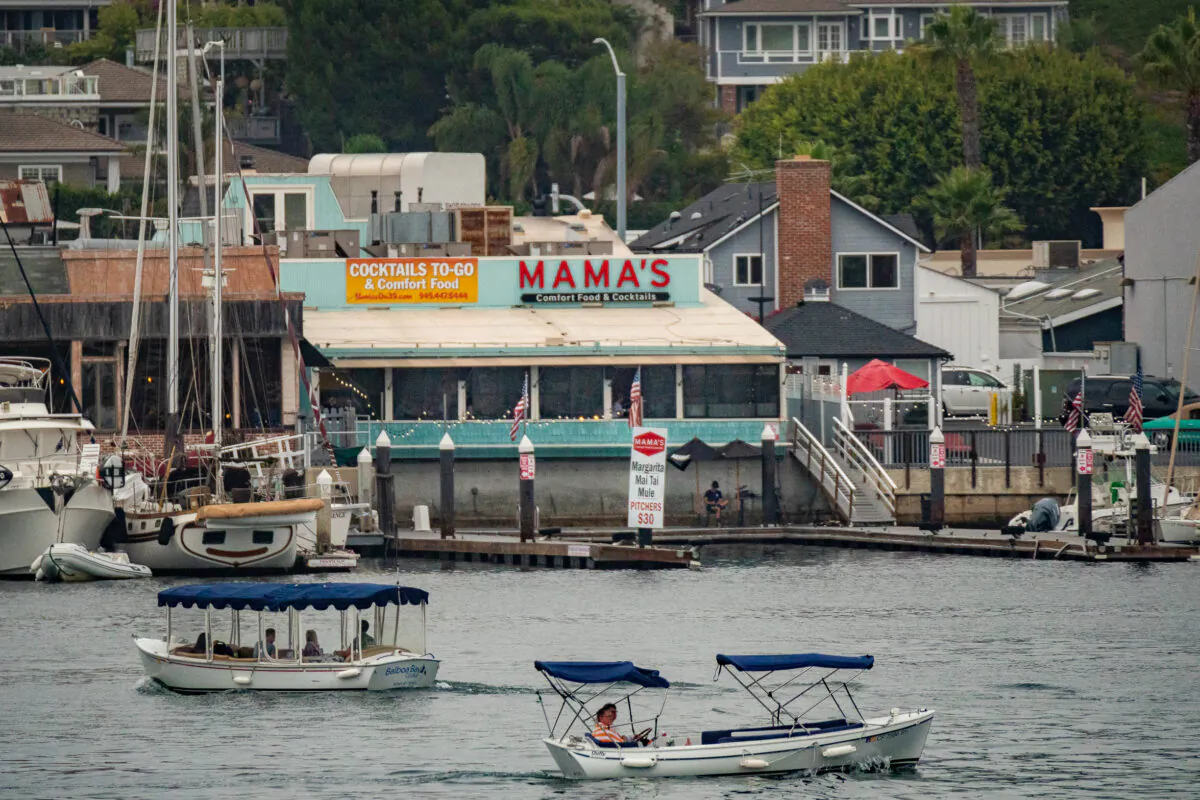 Boaters cruise in Newport Harbor past Mama's Comfort Food and Cocktails restaurant in Newport Beach, Calif., on September 8, 2020. (John Fredricks/The Epoch Times)