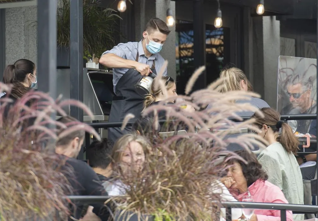 A server pours coffee for customers at a restaurant in Montreal on Aug. 1, 2021. (Graham Hughes/The Canadian Press)
