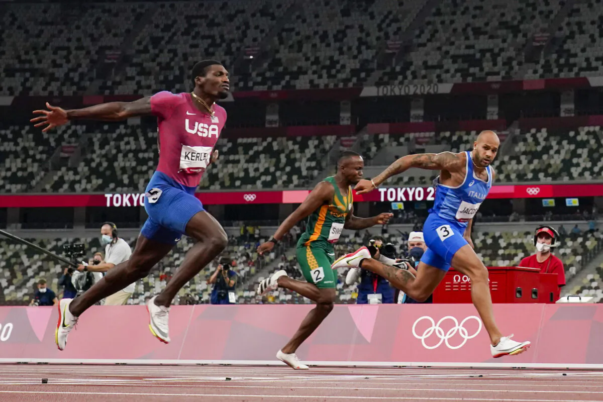 Lamont Jacobs (R) of Italy wins the men's the 100-meter final at the 2020 Summer Olympics in Tokyo, Japan, on Aug. 1, 2021. (David J. Phillip/AP Photo)