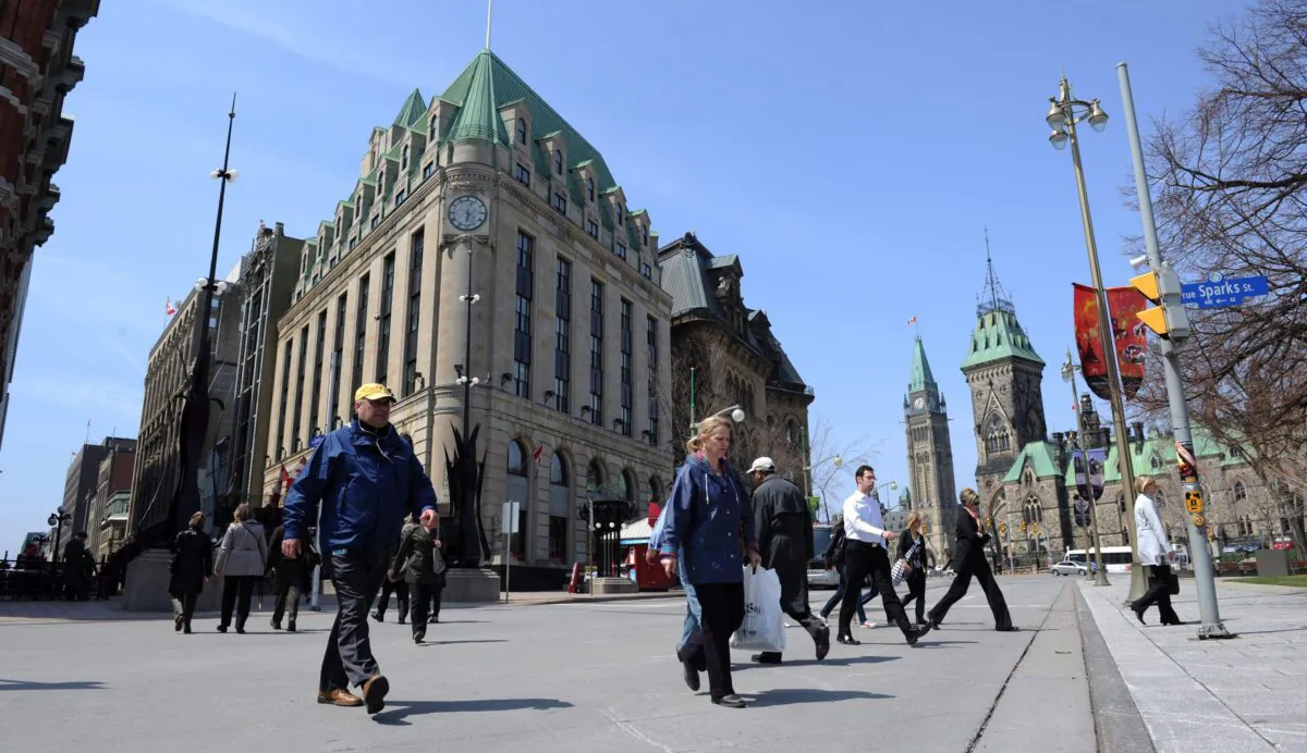 Pedestrians cross Elgin Street in view of Parliament Hill in Ottawa in a file photo. There’s a strong likelihood Canadians will be heading to the polls in a federal election this fall. (The Canadian Press/Sean Kilpatrick)
