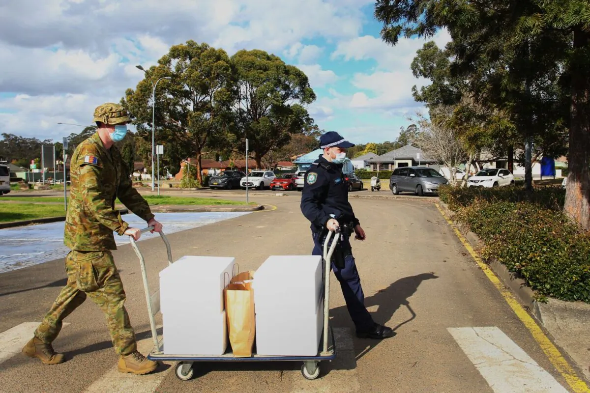 Australian Defence Force personnel and NSW police load food packages for delivery to people in lockdown at the Prairiewood Leisure Centre on Aug. 2, 2021 in Sydney, Australia. (Lisa Maree Williams/Getty Images)