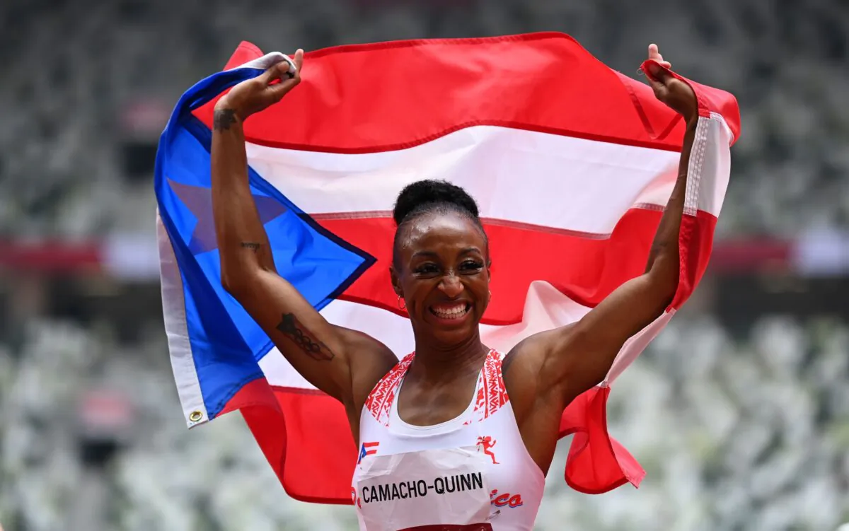 Jasmine Camacho-Quinn of Puerto Rico celebrates with her national flag after winning the women's 100 meters hurdles gold at Olympic Stadium in Tokyo, Japan, on Aug. 2, 2021. (Dylan Martinez/Reuters)
