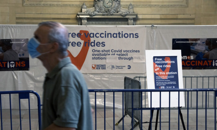 A man walks past vaccine infromation in Grand Central Terminal in New York City on July 27, 2021. (Spencer Platt/Getty Images)