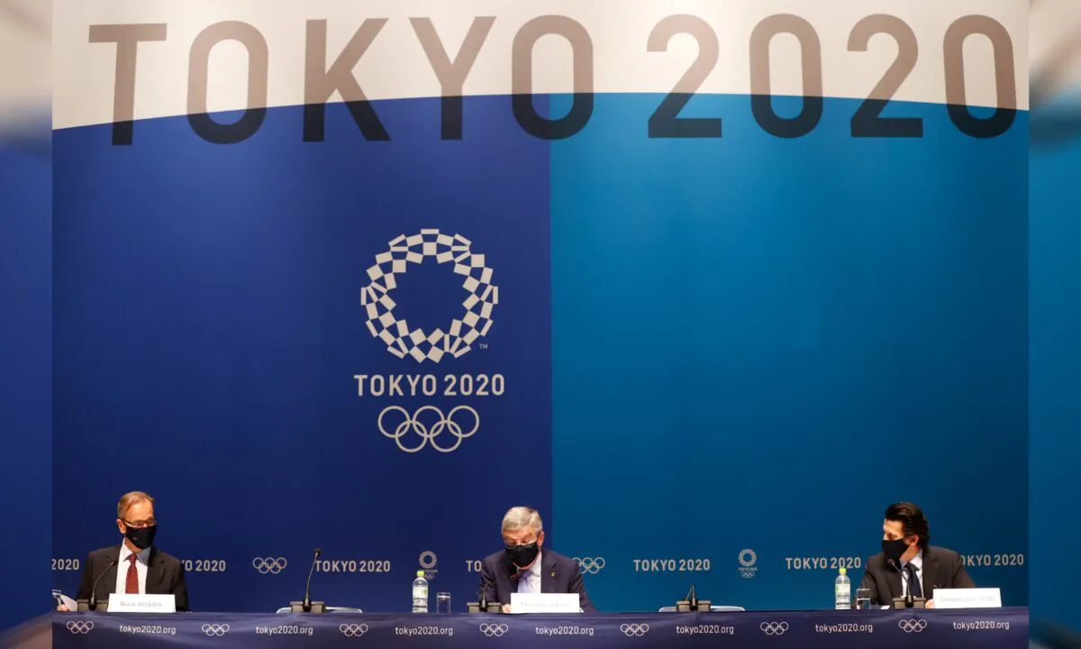 International Olympic Committee (IOC) President Thomas Bach with Director of Communications Mark Adams and Olympic Games Executive Director Christophe Dubi during the news conference in Tokyo, Japan, on July 17, 2021. (Phil Noble/Reuters)