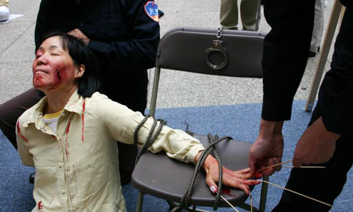 Reenactment of one of the torture methods employed by Chinese officials to coerce Falun Gong practitioners to renounce their faith. 
 (Minghui.org)